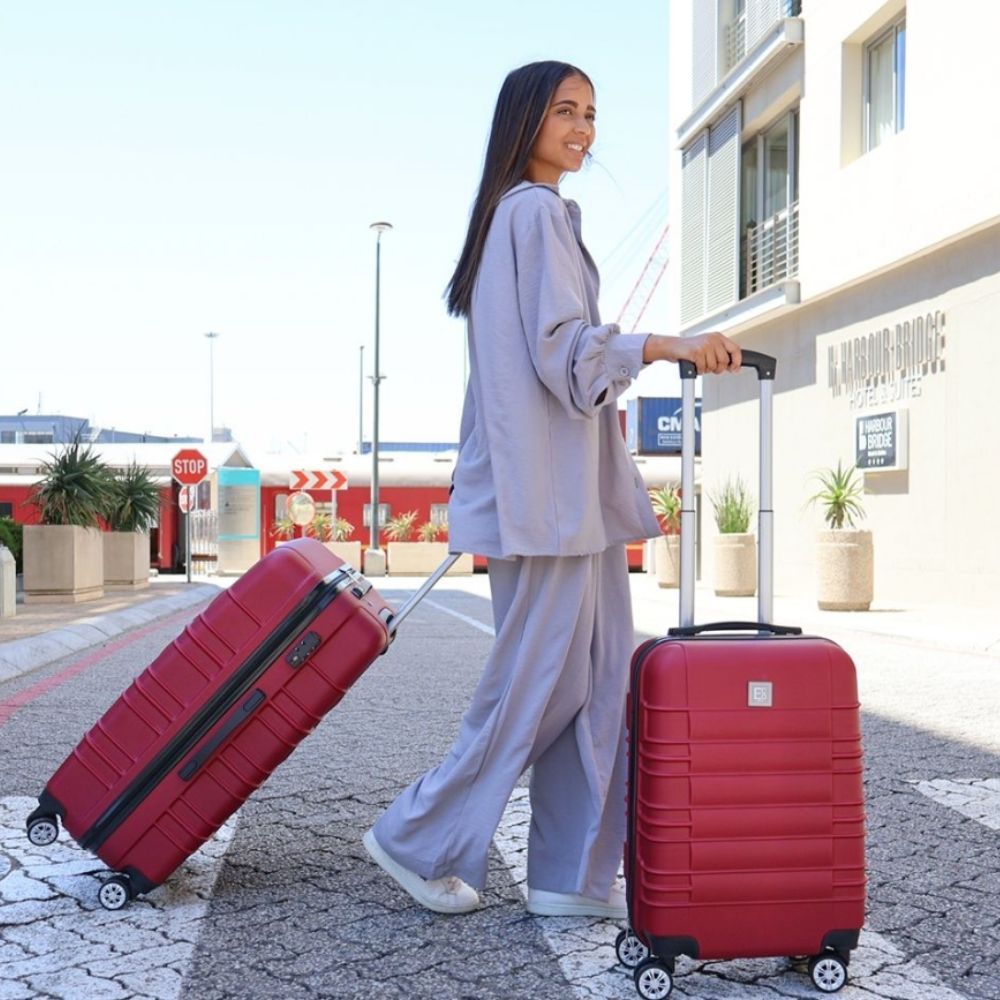 Lifestyle image of the Santorini hardshell luggage set in an outdoor setting, highlighting its soft blue tone, clean silhouette, and refined design made for serene, modern travel