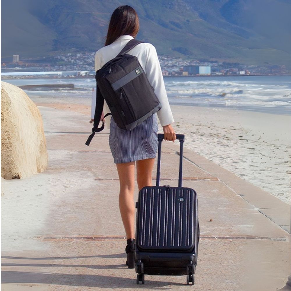 Woman walking along beachfront with Seattle eco-friendly luggage and backpack – lifestyle product image 01